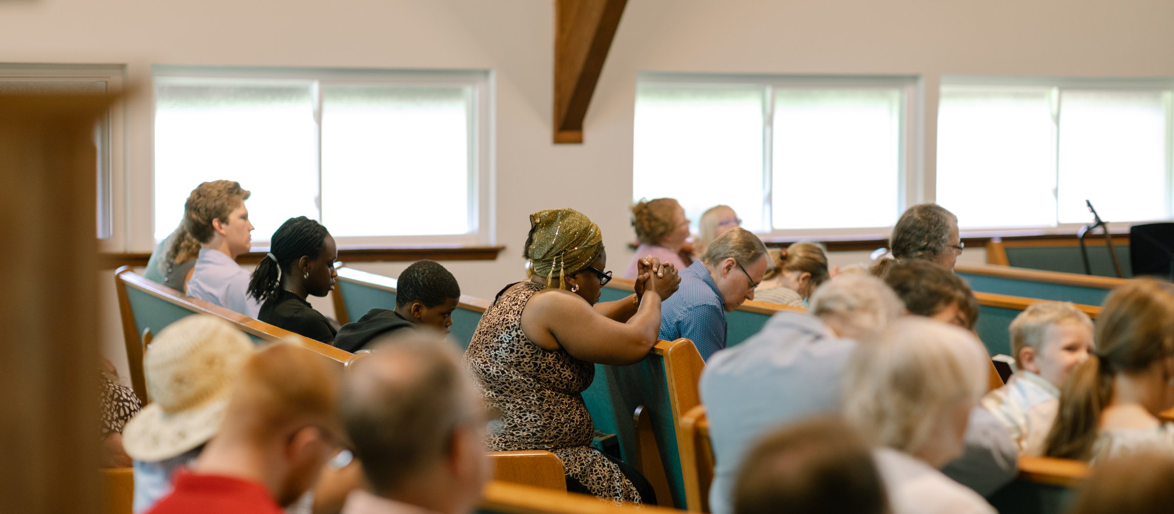 A parishioner with hands clasped in prayer during the Sunday liturgy at St. Andrew's.