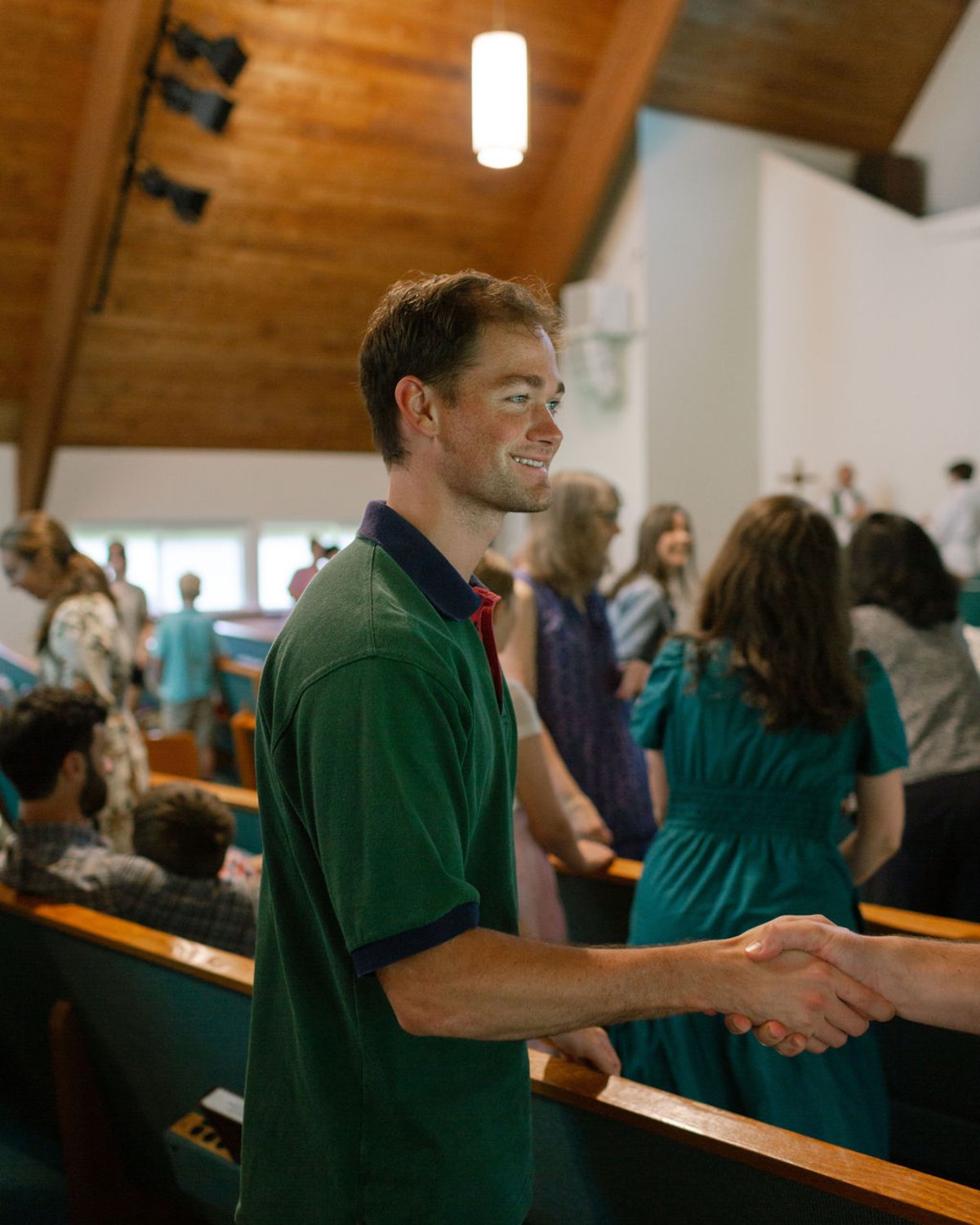 A parishioner exchanges the peace with a neighbor during the Sunday liturgy.