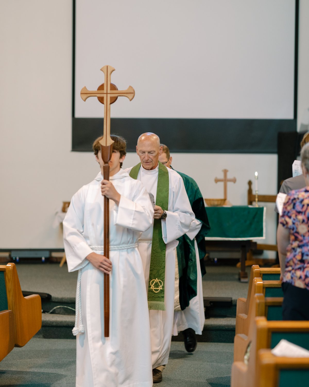 Acolyte and rector in procession down the aisle.